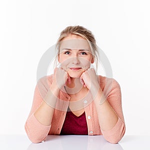 Decided blond woman sitting in sparse office smiling