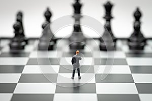 Decision making or leadership in business strategy concept, brave miniature figure businessman thinking and standing on