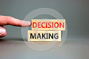Decision making symbol. Concept words Decision making on wooden blocks. Beautiful grey table grey background. Businessman hand.