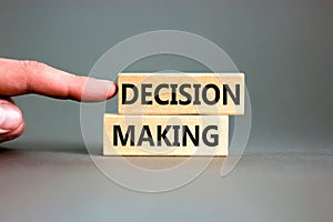 Decision making symbol. Concept words Decision making on wooden blocks. Beautiful grey table grey background. Businessman hand.