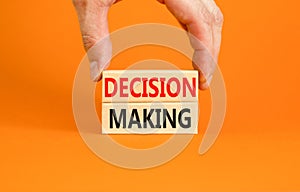 Decision making symbol. Concept words Decision making on wooden blocks. Beautiful orange table orange background. Businessman hand