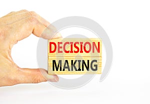 Decision making symbol. Concept words Decision making on wooden blocks. Beautiful white table white background. Businessman hand.