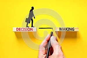 Decision making symbol. Concept words Decision making on wooden blocks. Beautiful yellow table yellow background. Businessman hand
