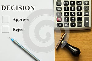 Decision paper with blue pen, calculator and rubber stamp
