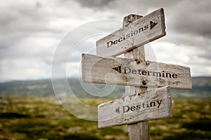 decisions determine destiny text engraved on old wooden signpost outdoors in nature