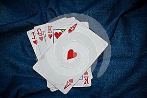 Deck of cards with Ace of Hearts at front in denim background.