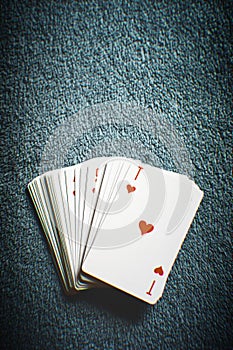A deck of cards on a dark gray table, ace of hearts first, top view with copy space