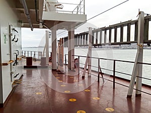 The deck of a cargo ship. Red floor and white walls.