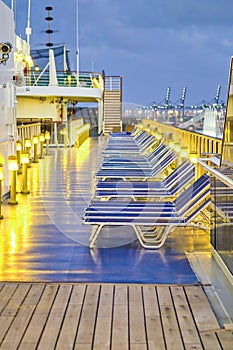 Deck chairs along a cruise ship at night. Vacation concept