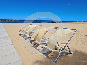 deck chairs on the beach blown by the wind