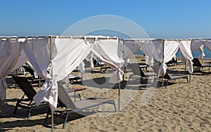 deck chairs on the beach with the curtains to shelter from the h