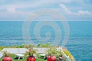 Deck chairs on a high ground terrace next to an ocean on a sunny windless day