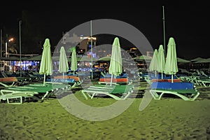 Deck chairs and umbrellas on the beach at night