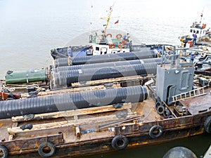 The deck lay barge. Pipes and Lifting cranes on the ship. Equipment for laying a pipeline on the seabed