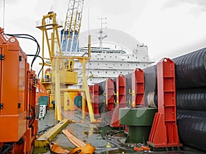 The deck lay barge. Pipes and Lifting cranes on the ship. Equipment for laying a pipeline on the seabed