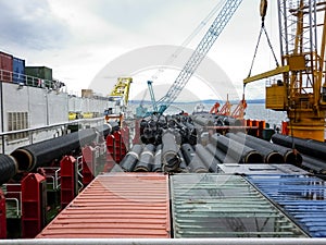 The deck lay barge. Pipes and Lifting cranes on the ship. Equipment for laying a pipeline on the seabed