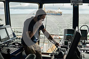 Deck navigation officer on the navigation bridge. He looks through binoculars