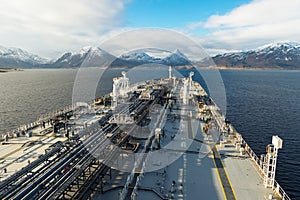 Deck of a new oil tanker with mountain background.