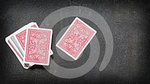 Deck of playing cards and one card separately face down on a black table