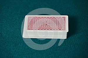 a deck of red cards on the green game mat photo