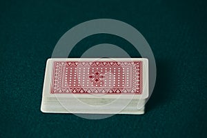 a deck of red cards on the green game mat photo