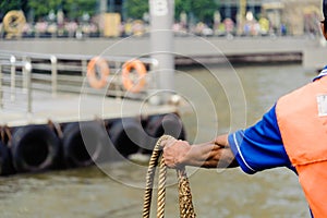 Deck sailor working with rope while mooring to pier