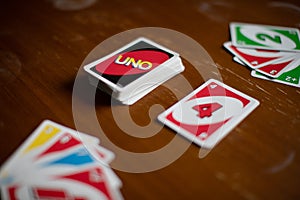 Deck of Uno game cards scattered all over on a table. American card game.