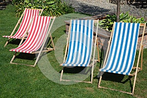 Deckchair chaise chair in cafÃ© garden park gras, with blue red stripes relax