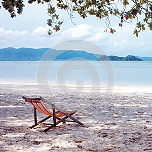 Deckchair in the shade of tree, chair, beach.