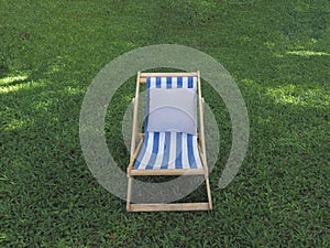 deckchair with white pillow on green grass backyard