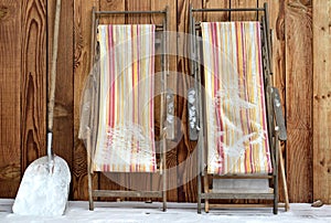 Deckchairs folded  on a terrace covered with snow