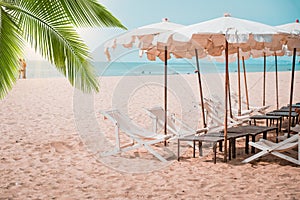 Deckchairs And Parasol With Palm Trees In The Tropical Beach.Beach in Thailand Asia and umbrellas on the beach