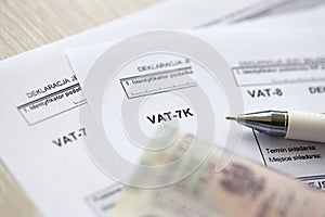 Declaration for tax on goods and services VAT-8, VAT-7K, VAT-7 form on accountant table with pen and polish zloty money photo