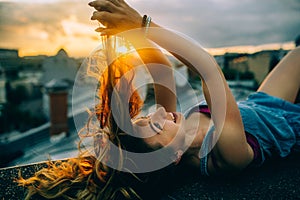 Beautiful woman rests on the roof, hipster portrait outdoors, sunset time, city, rest time, light, hipster photo, happy face, smil