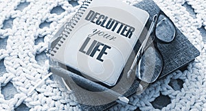 Declutter Your Life on the cover of notebook, eye glasses and pen. Concept meaning Free Less Chaos Fresh Clean Routine