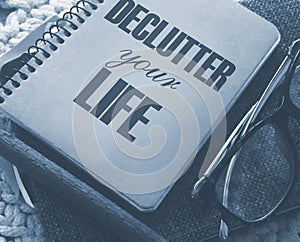 Declutter Your Life on the cover of notebook, eye glasses and pen. Concept meaning Free Less Chaos Fresh Clean Routine