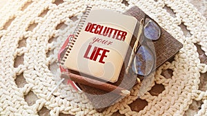 Declutter Your Life on the cover of notebook, eye glasses and pen. Concept meaning Free Less Chaos Fresh Clean Routine. Career and