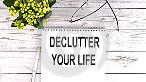 DECLUTTER YOUR LIFE text concept write on notebook on wooden background