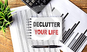 DECLUTTER YOUR LIFE text on a notebook with chart and calculator