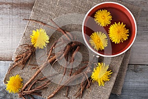 Decoction of flowers and dandelion roots on a vintage wooden background with copy space, medicinal herbs, herbal medicine,