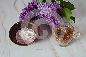 Decoction of lilac flowers Syringa vulgaris and potato starch on a marble background