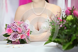 Decollete of young bride, which sits at table photo