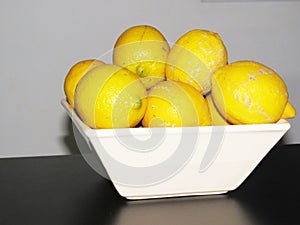 decomposing lemons stacked in a bowl photo