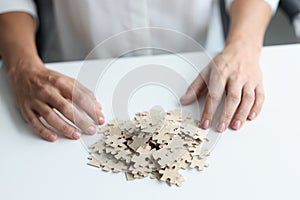 Decomposition of puzzles and female hands on table closeup