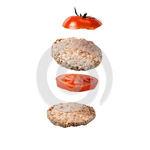 A deconstructed sandwich with crispy bread and tomato slices are floating on a white isolated background. Flying Ingredients