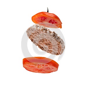 Deconstructed sandwich with crispy bread and tomato slices flying on a white isolated background. Flying Ingredients