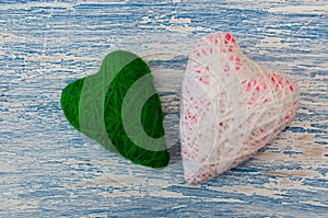 Decor for the day of the holy Valentine. Two knitted hearts: white and green