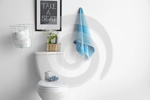 Decor elements, necessities and toilet bowl near wall, space for text. Bathroom interior