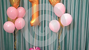 Decor of pink and gold balloons and the number 1 for the baby`s birthday.