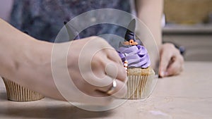 Decorate cup-cake with icing hat and legs. Muffin like witch. Halloween concept